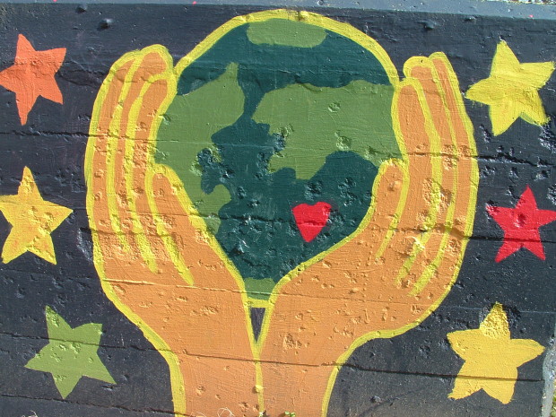 Mural of hands holding a green Earth with a heart in it.