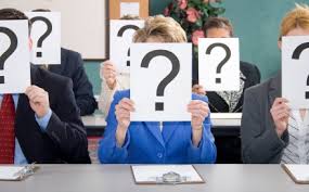 Anonymous business people holding up question marks